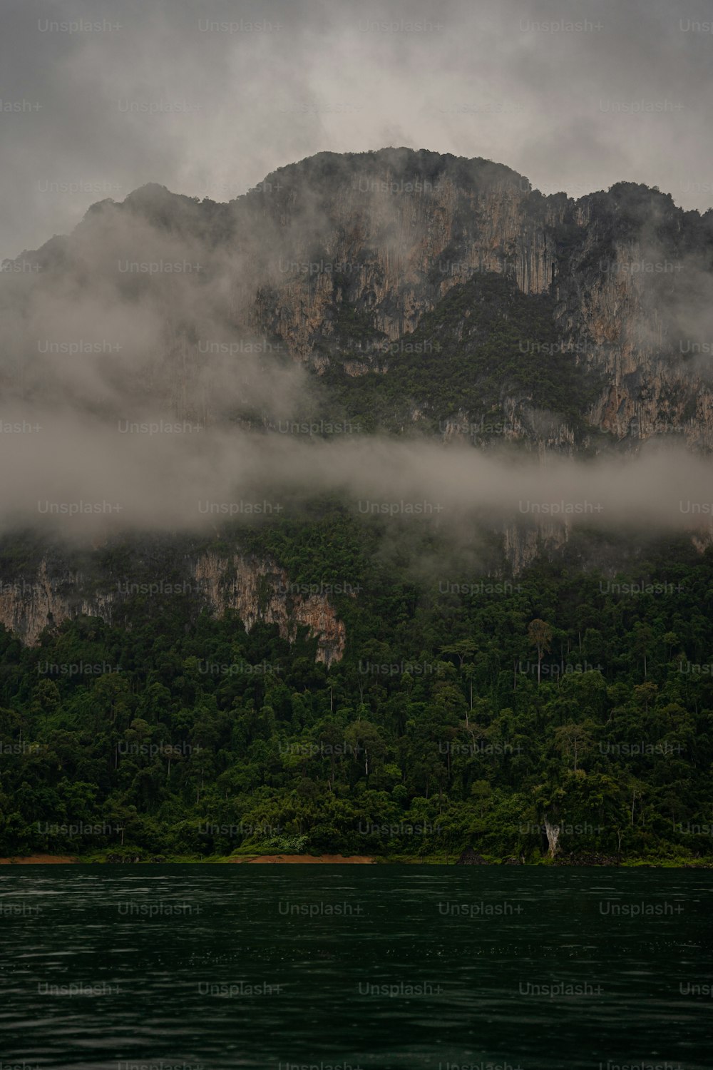 a large mountain covered in fog and clouds