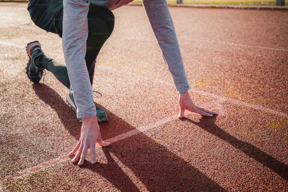 a person bending over on a running track