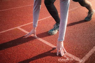 un primer plano de los pies de una persona en una pista de atletismo