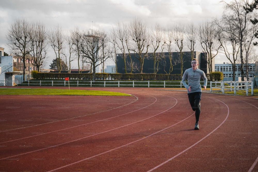 a man running on a track with trees in the background