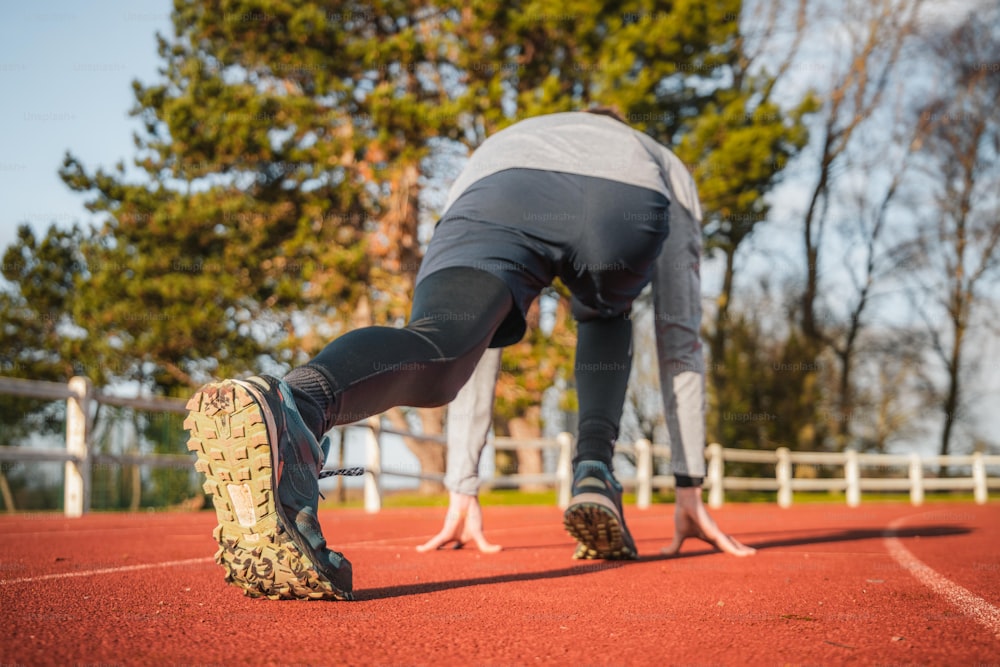 a person bending over on a red track