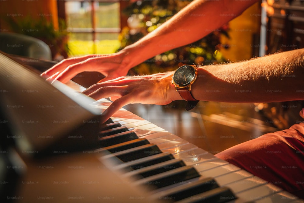 a man is playing a piano with a watch on his wrist