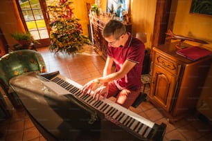 a man in a red shirt playing a piano