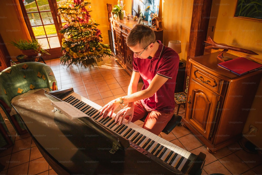 Un hombre con una camisa roja tocando un piano