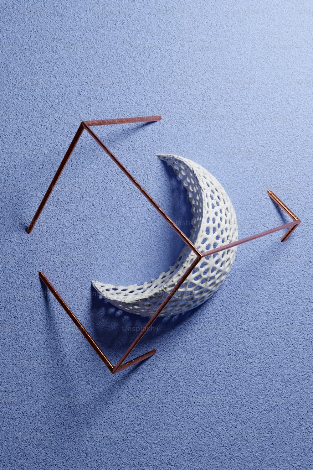 Eine Skulptur eines Halbmondes auf blauer Oberfläche
