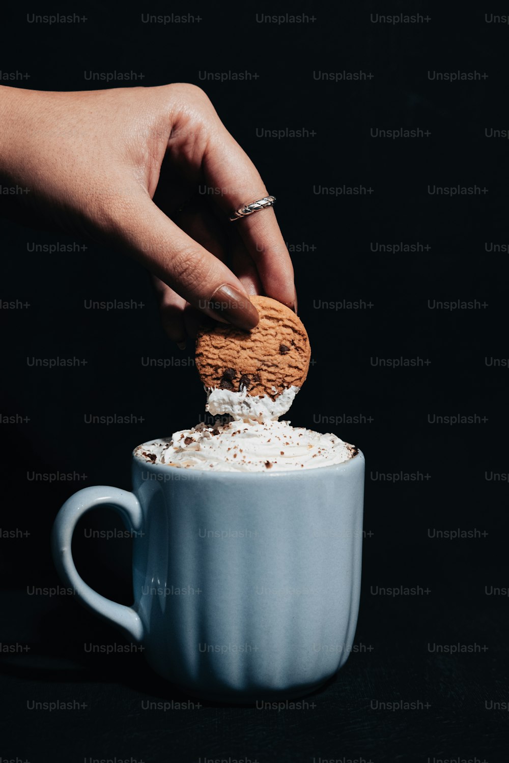 a person dipping a cookie into a cup of coffee