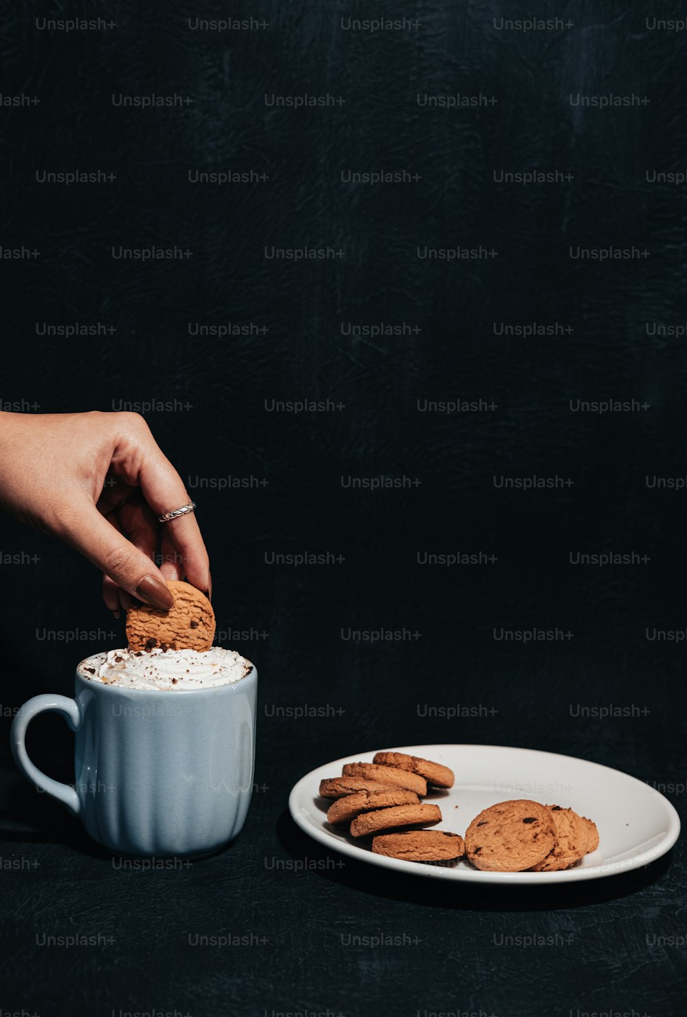 a person dipping a cookie into a cup of coffee