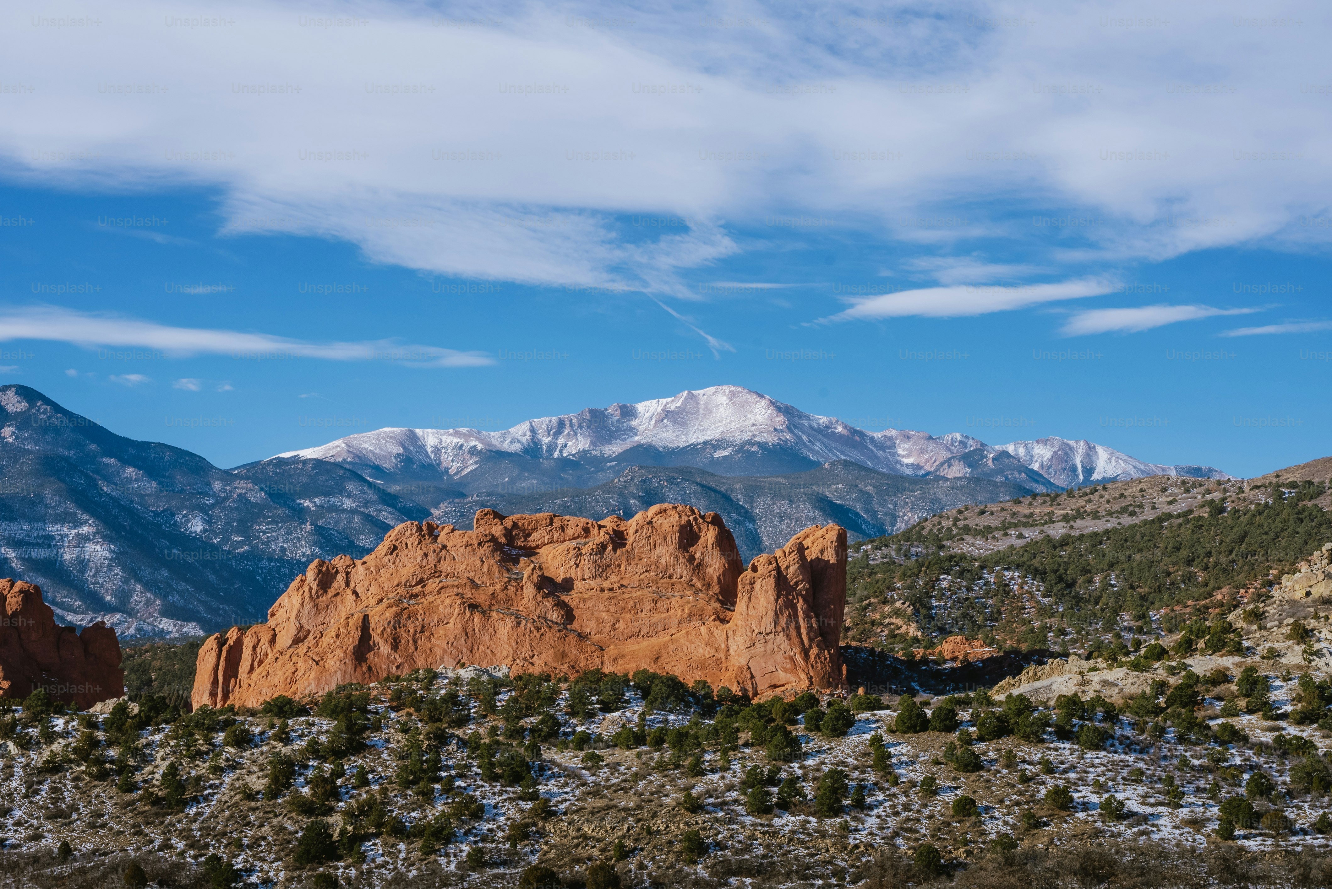 a mountain range with snow capped mountains in the background