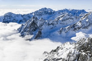 eine Bergkette mit Schnee und Wolken bedeckt