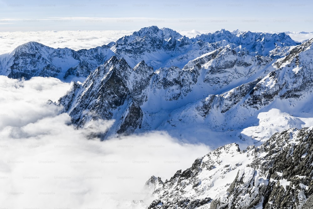 a mountain range covered in snow and clouds