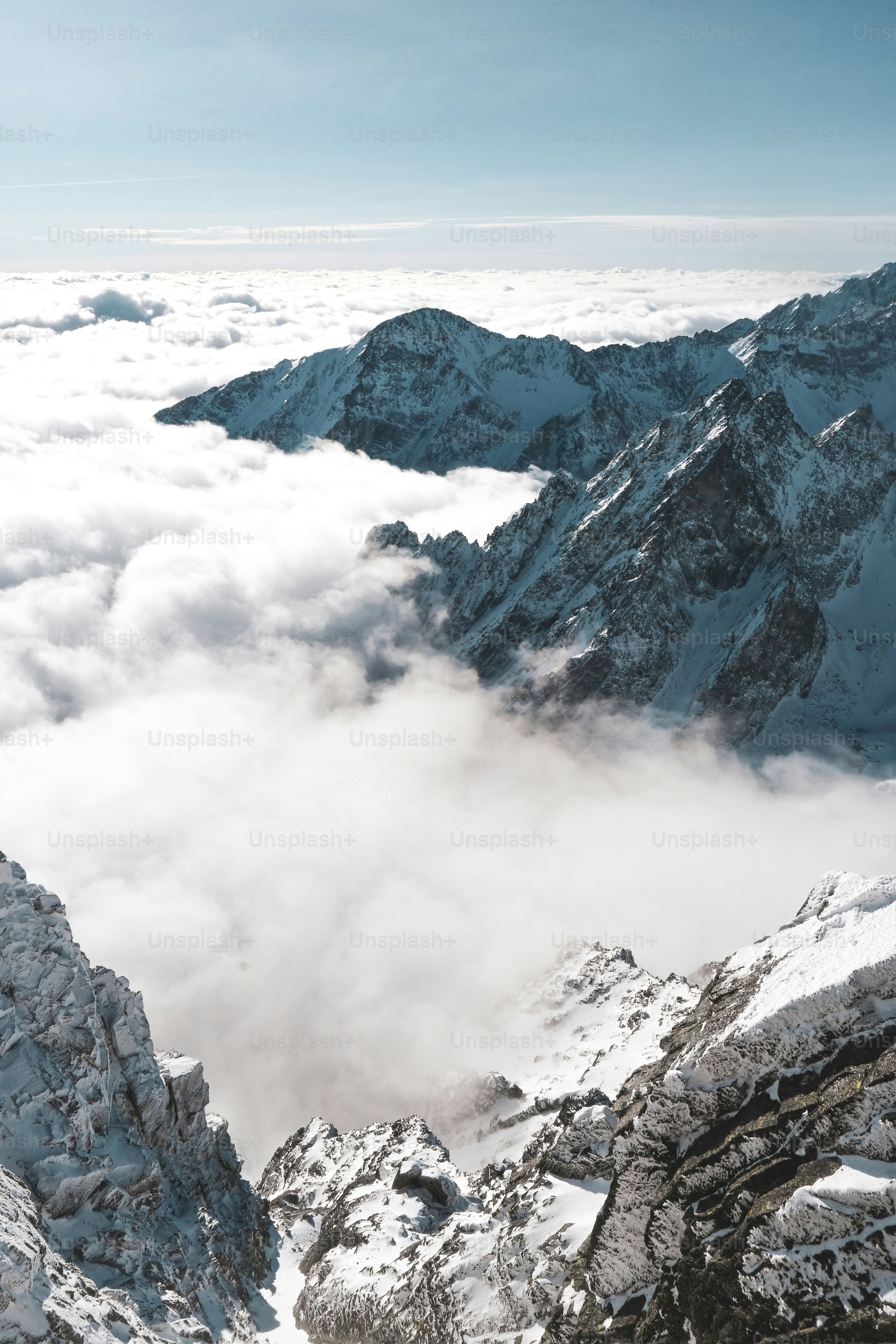 eine Bergkette mit Schnee und Wolken bedeckt
