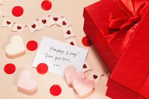 a valentine's day card next to a red gift box