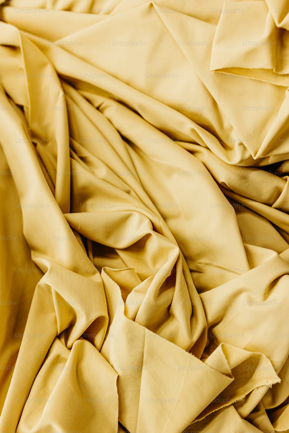 a close up of a bed with a yellow comforter