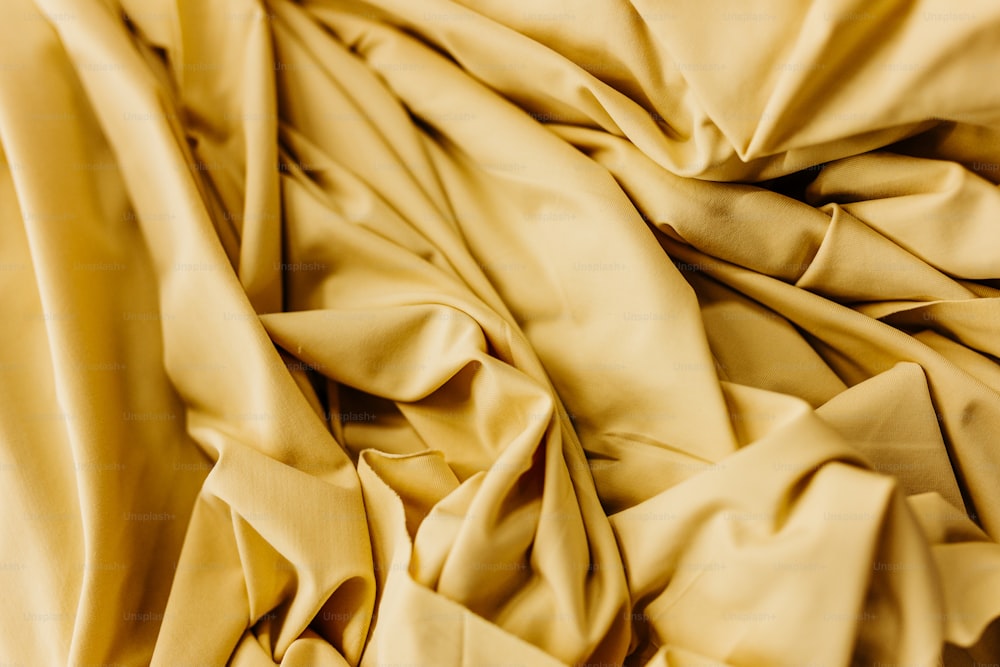 a close up of a bed with a yellow comforter
