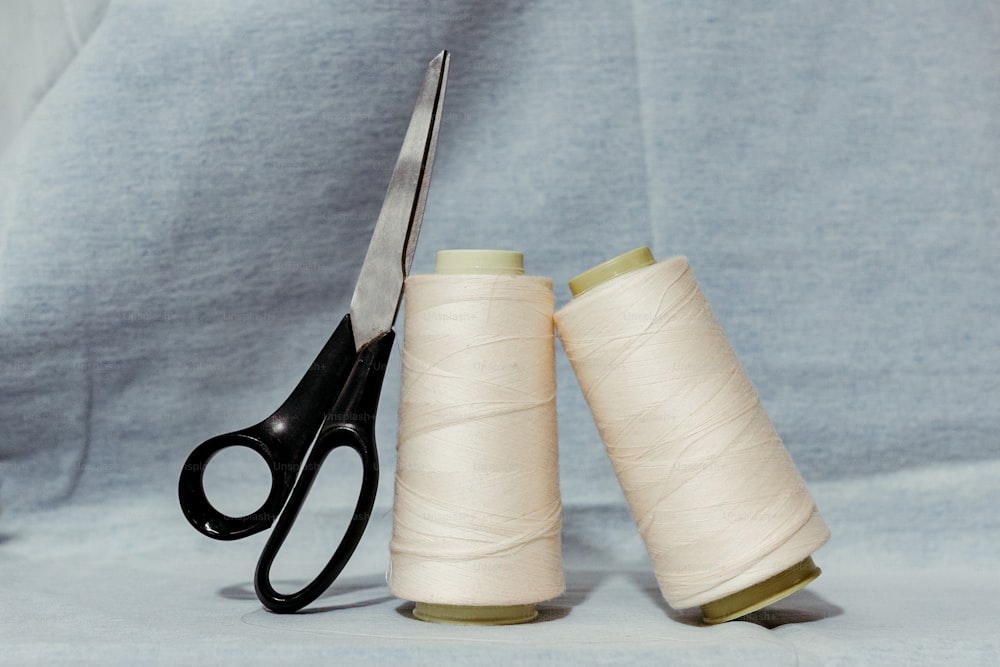 a pair of scissors and a spool of thread
