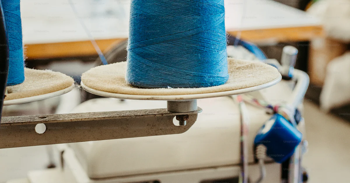 Two blue spools of thread on a sewing machine photo – Stitching Image ...