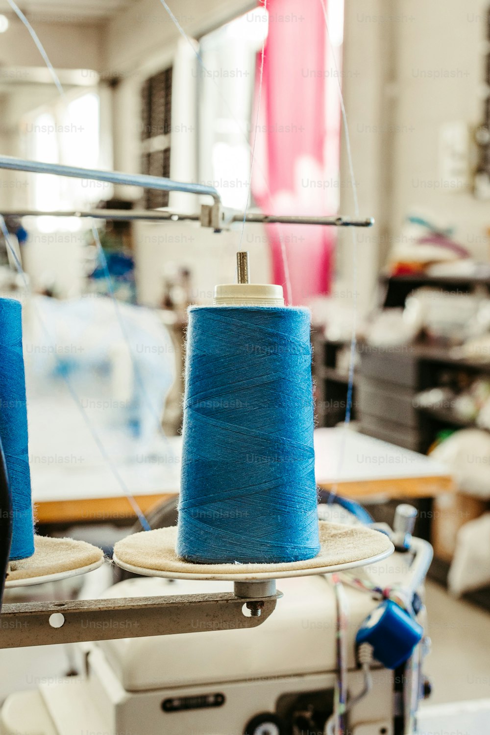 two blue spools of thread on a sewing machine