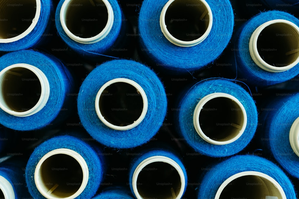 a bunch of blue rolls of yarn stacked on top of each other