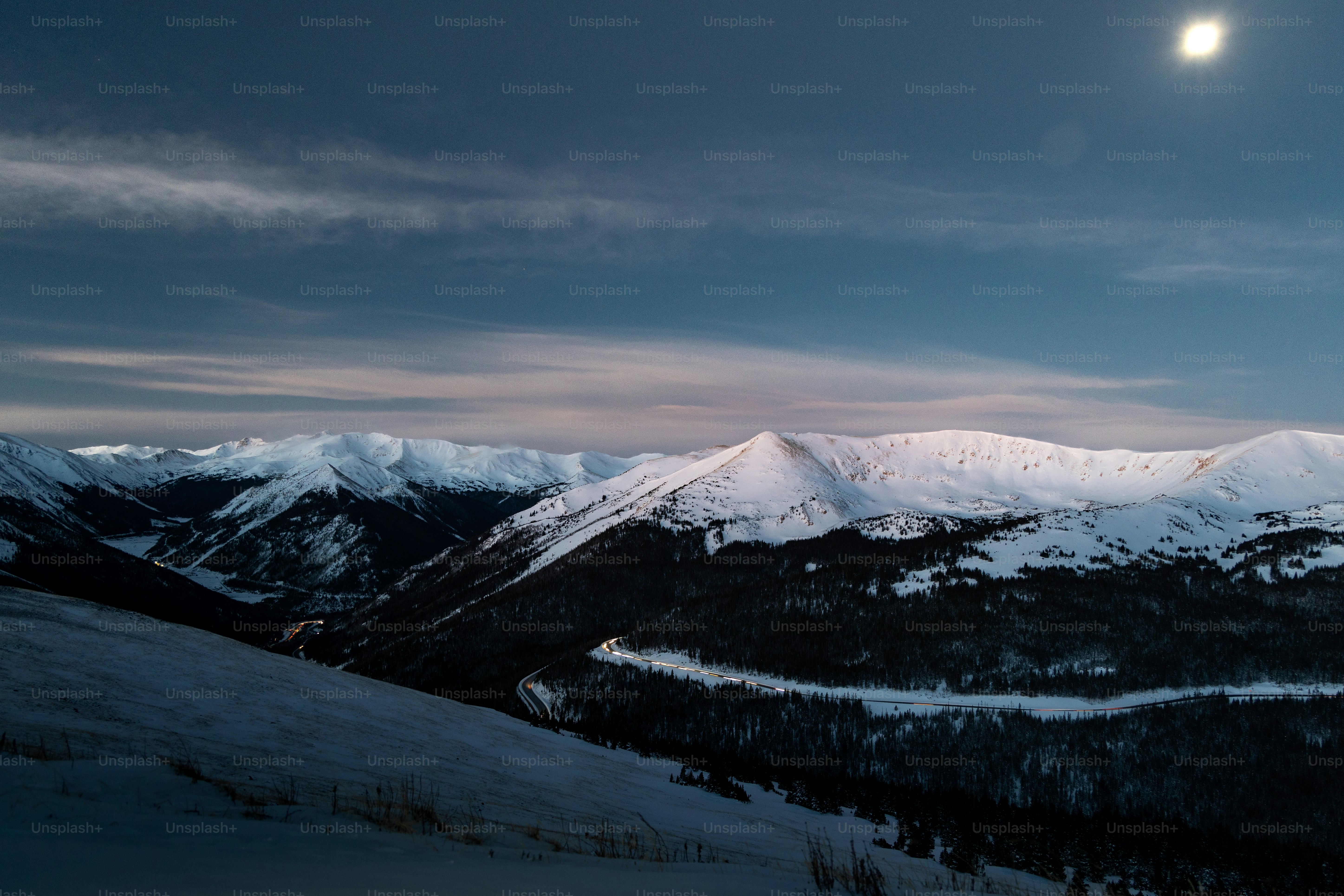 a view of a snowy mountain range at night