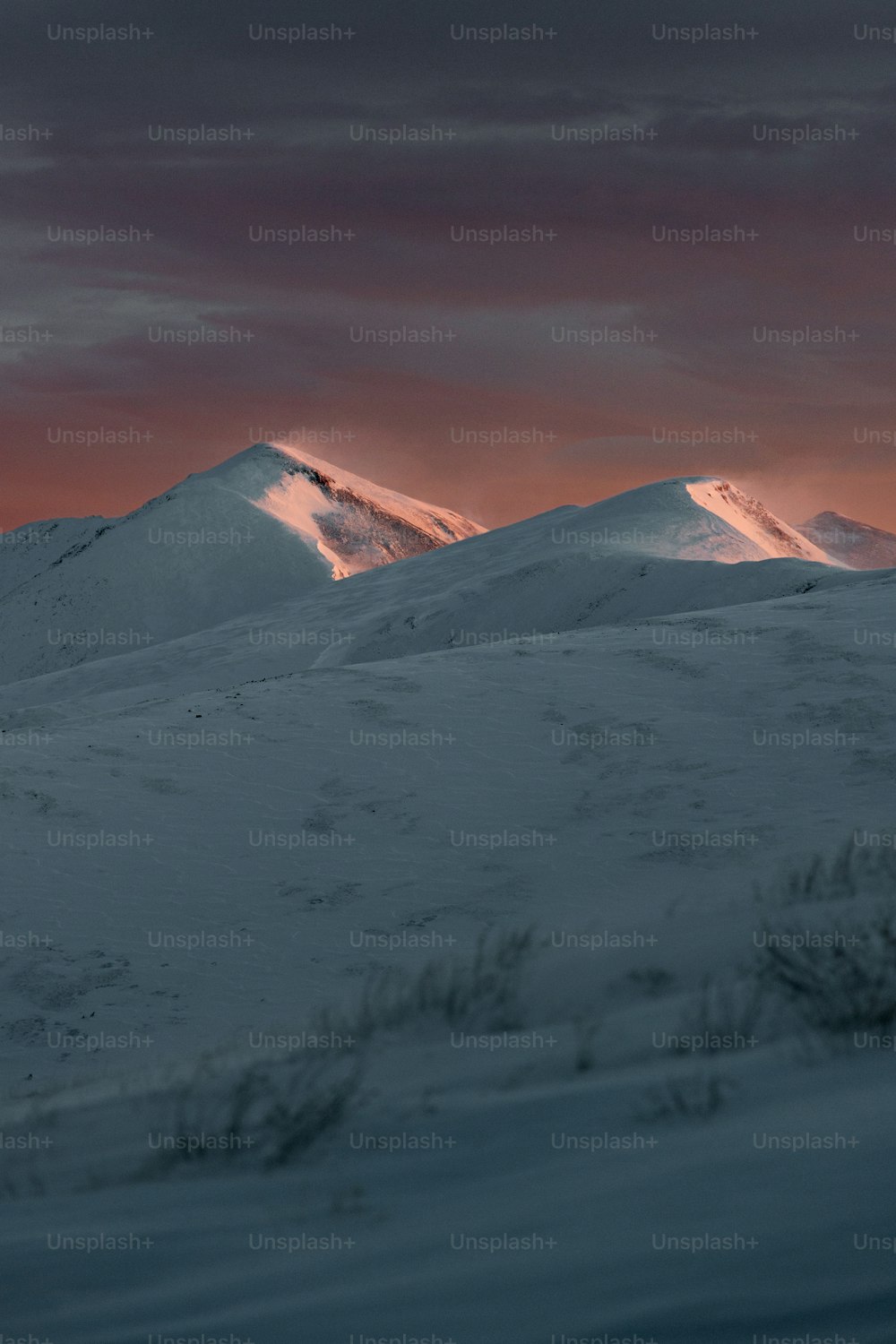 Una montagna coperta di neve sotto un cielo nuvoloso