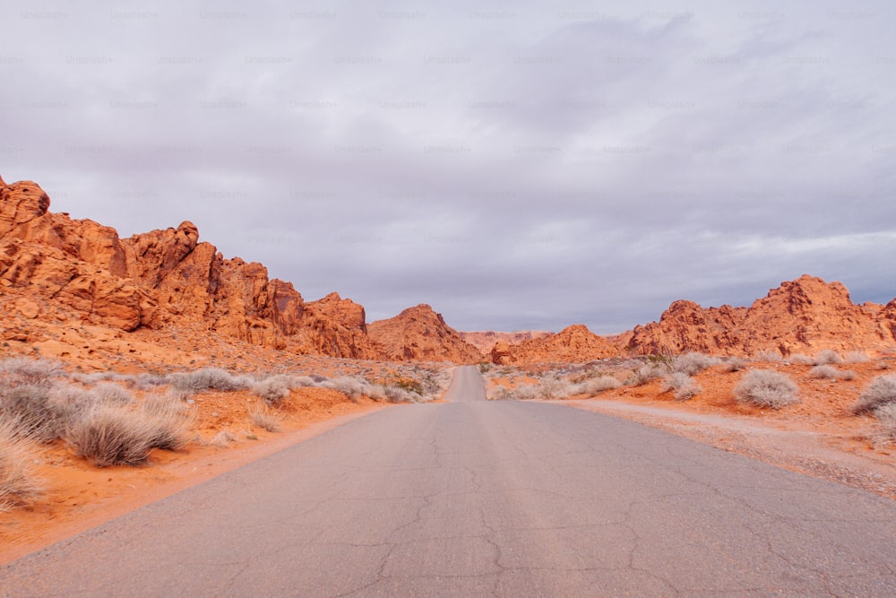 Une route au milieu d’un désert avec des montagnes en arrière-plan
