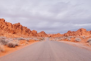 uma estrada no meio de um deserto com montanhas ao fundo