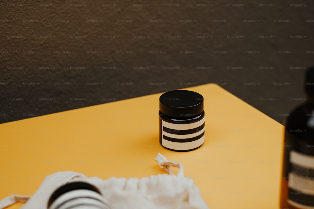 黄色いテーブルの上に置かれた黒と白の容器のペア