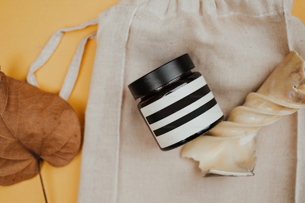 a black and white jar sitting on top of a bag