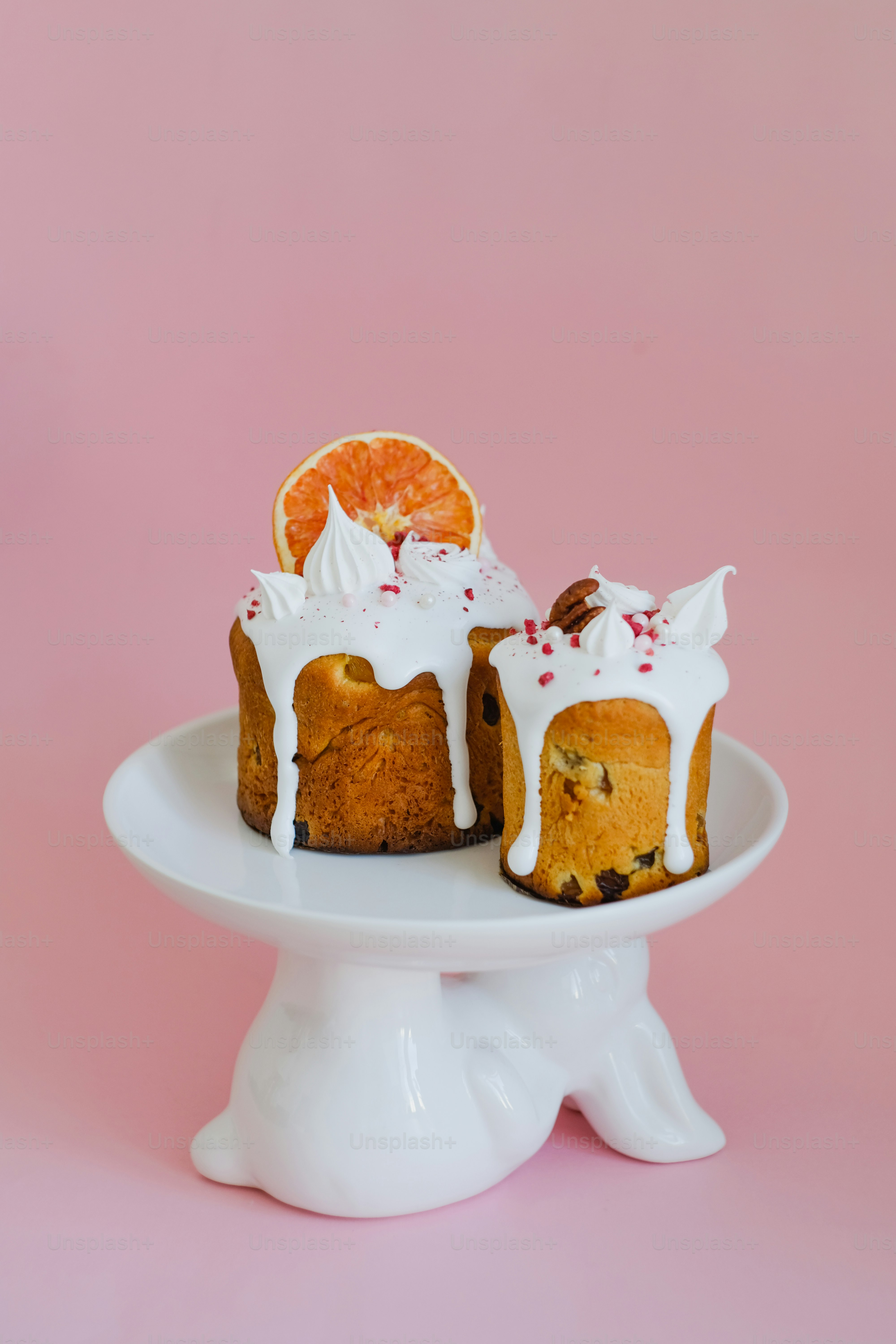 ein weißer Teller mit zwei mit Zuckerguss bedeckten Kuchen