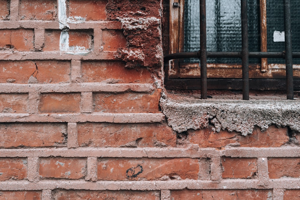 a brick wall with a window and bars on it