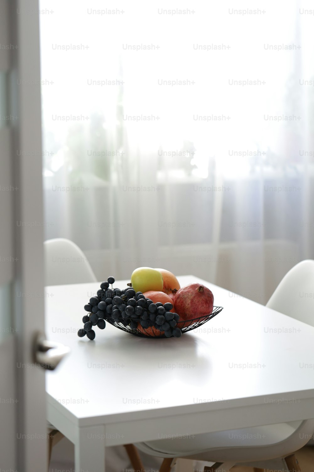 uma tigela de frutas está sentada em uma mesa
