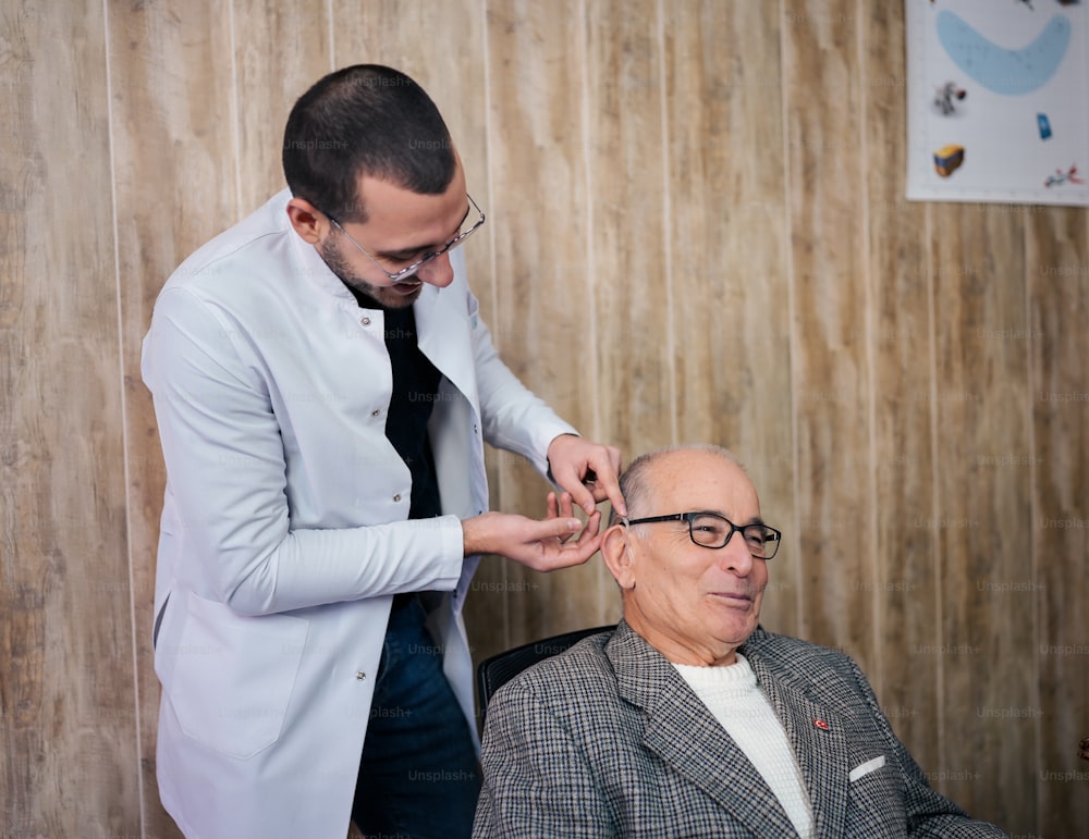 a man getting his hair cut by a man in a suit