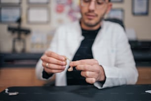 a man in a white coat is holding a ring