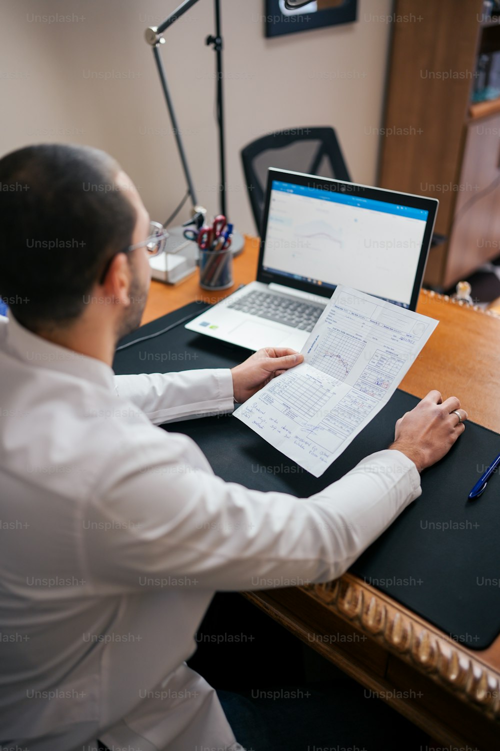 Ein Mann sitzt am Schreibtisch und arbeitet an einem Laptop