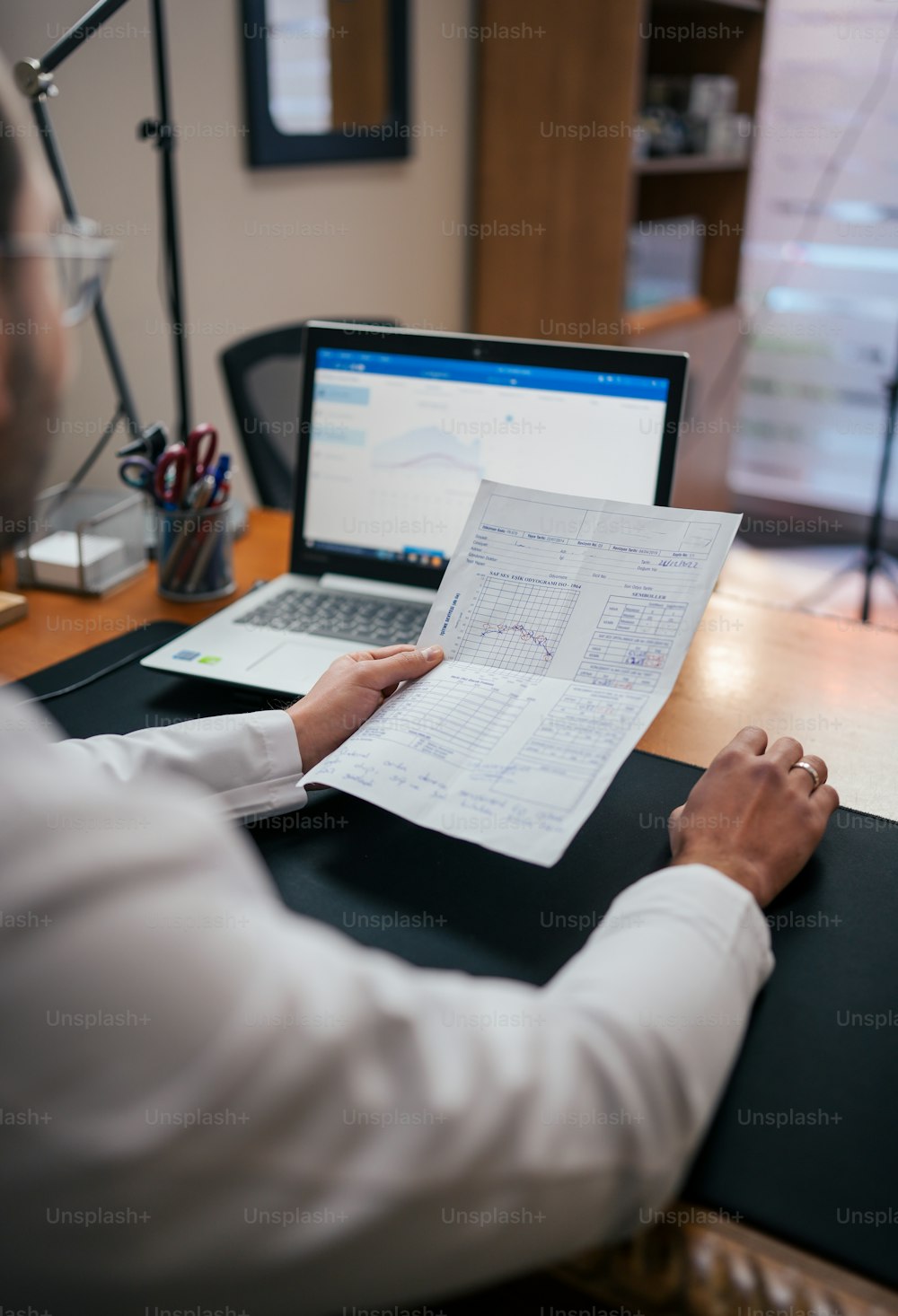 a man sitting at a desk with a laptop and papers