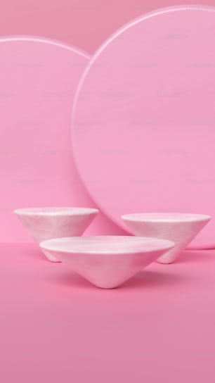 Un conjunto de tres placas blancas sobre un fondo rosa