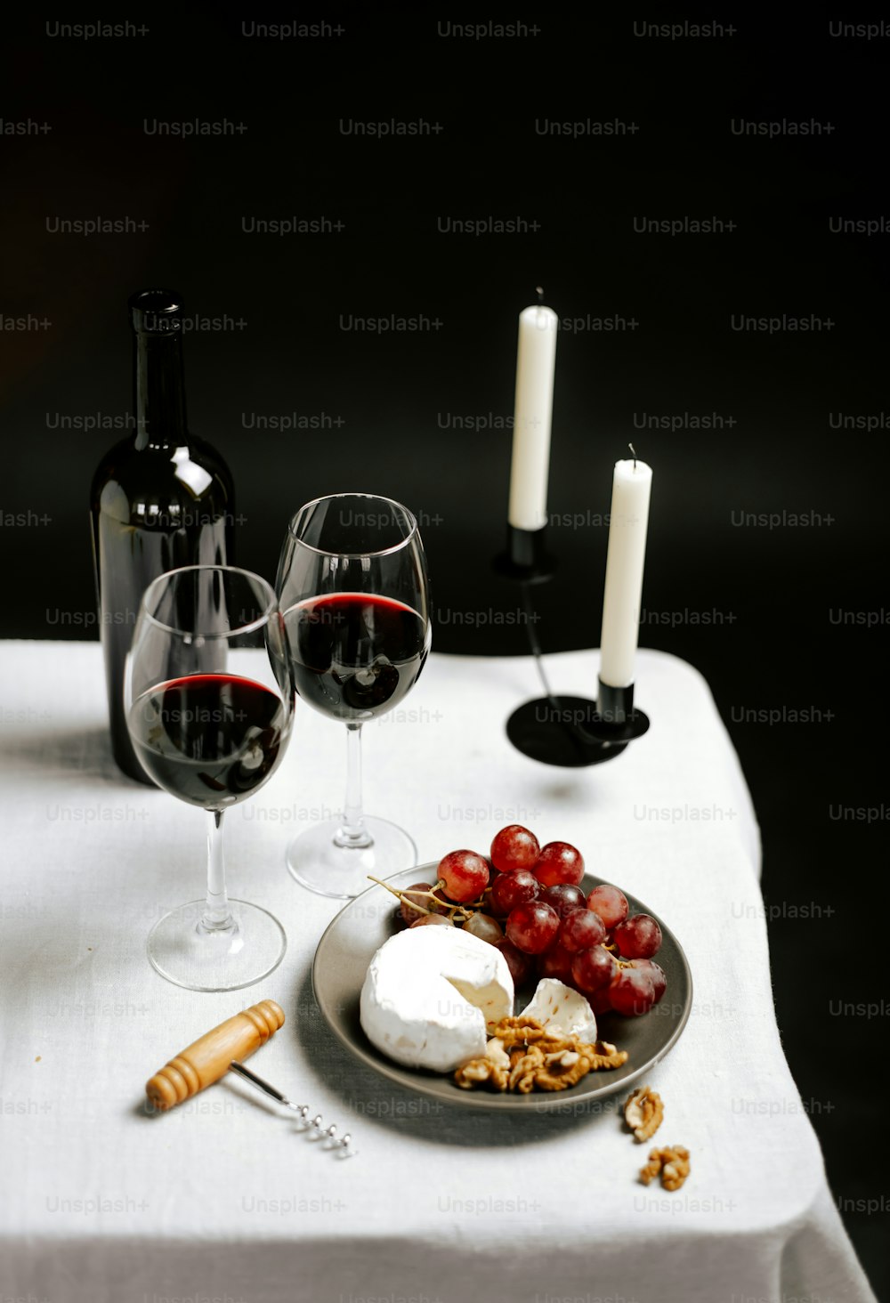 ein Tisch mit einem Teller Essen und zwei Gläsern Wein