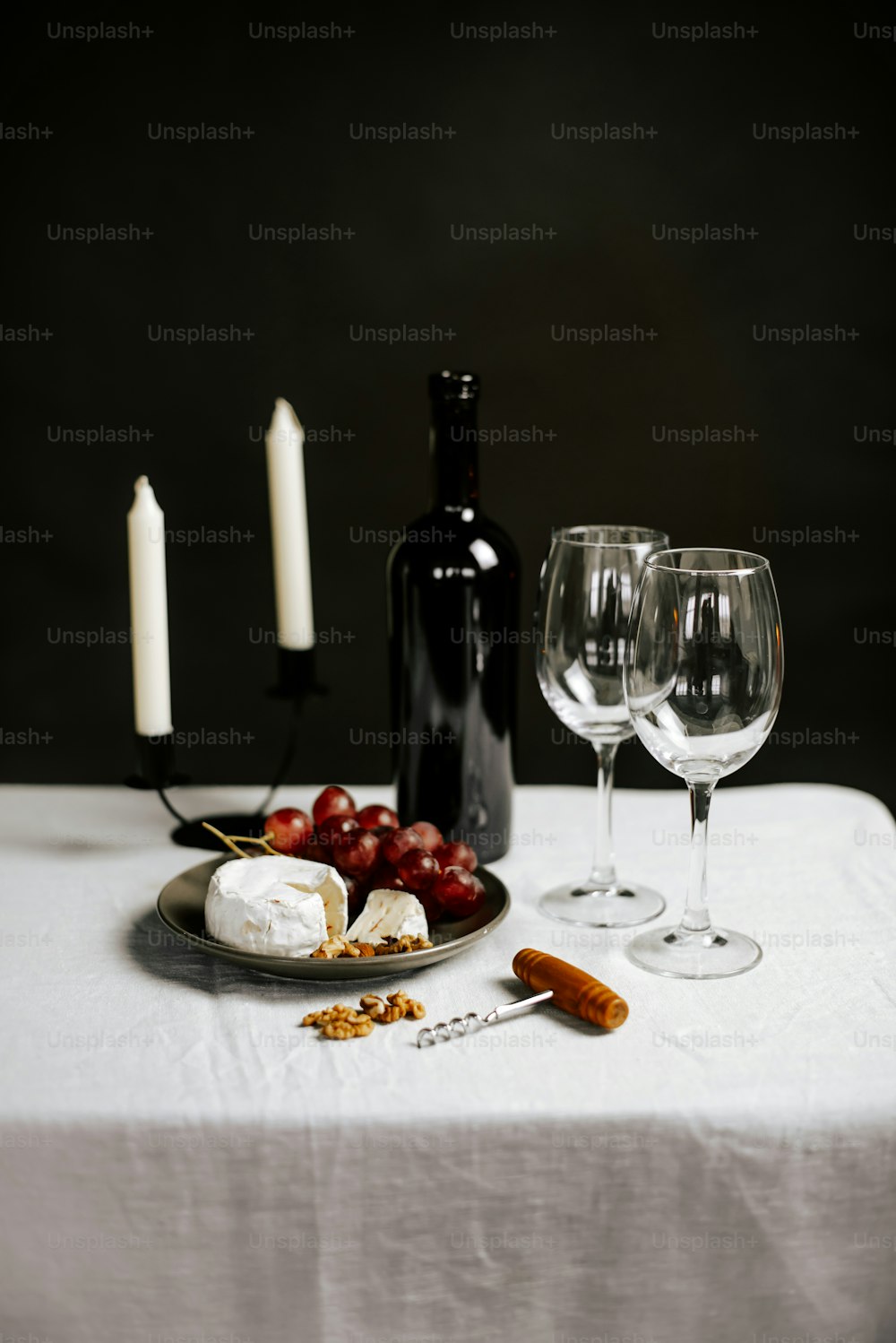 a table topped with a plate of food and two wine glasses