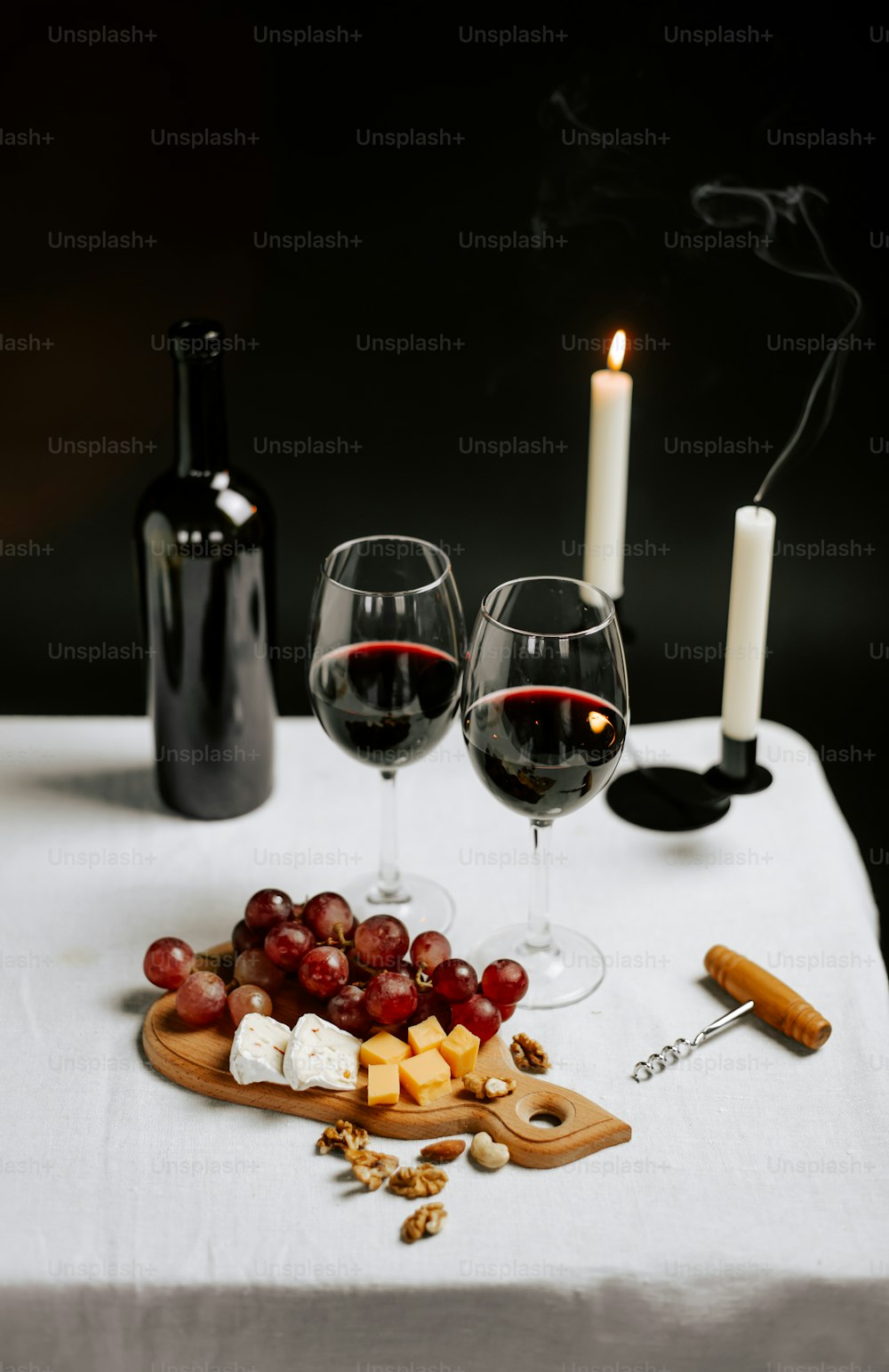 une table surmontée de deux verres de vin et de fromage