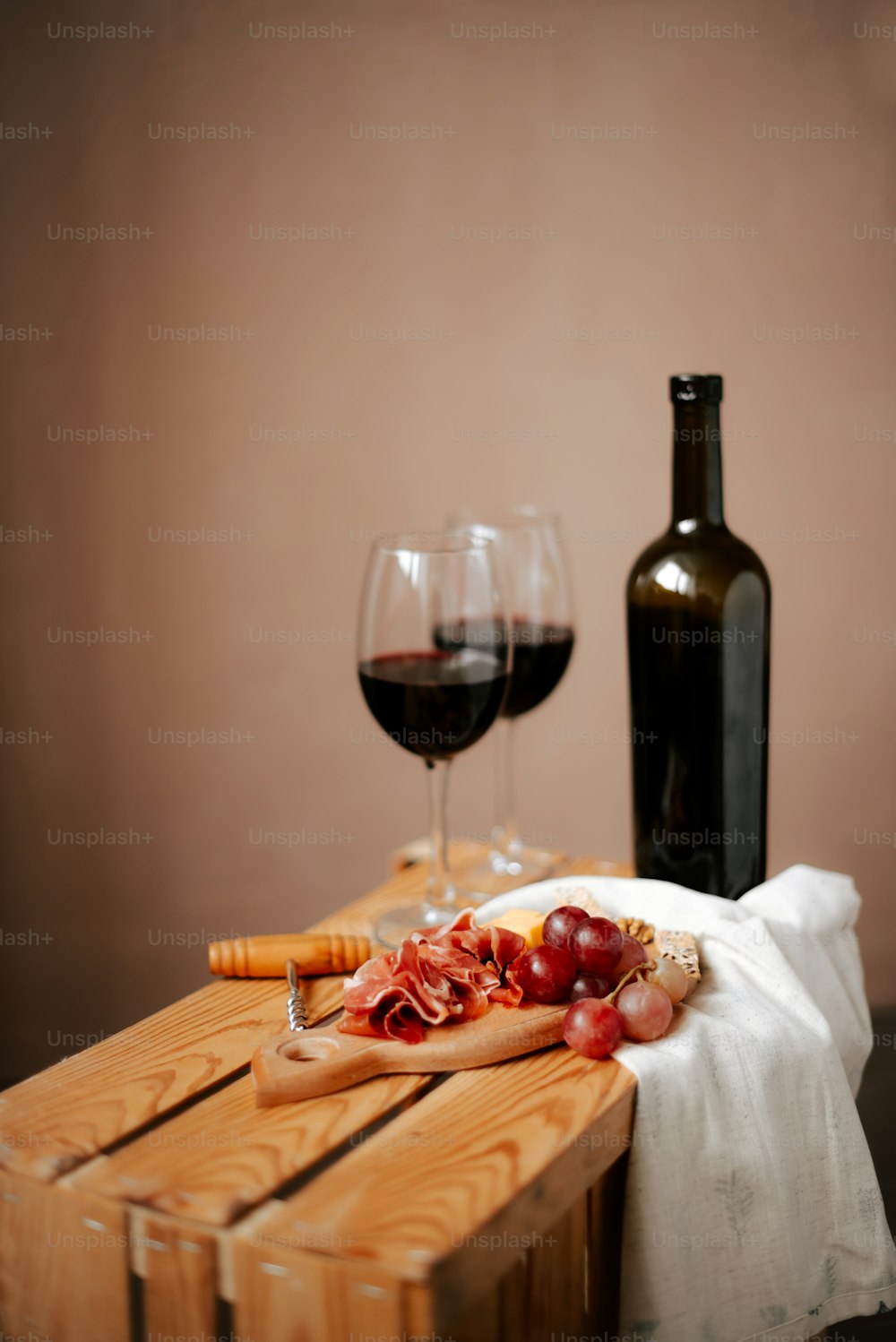 a wooden table topped with a bottle of wine and a glass of wine