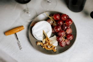 a plate with grapes, crackers, cheese and crackers on it