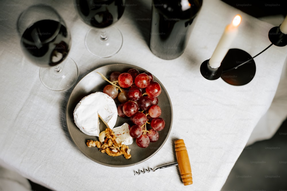 a plate of grapes, crackers, and cheese on a table