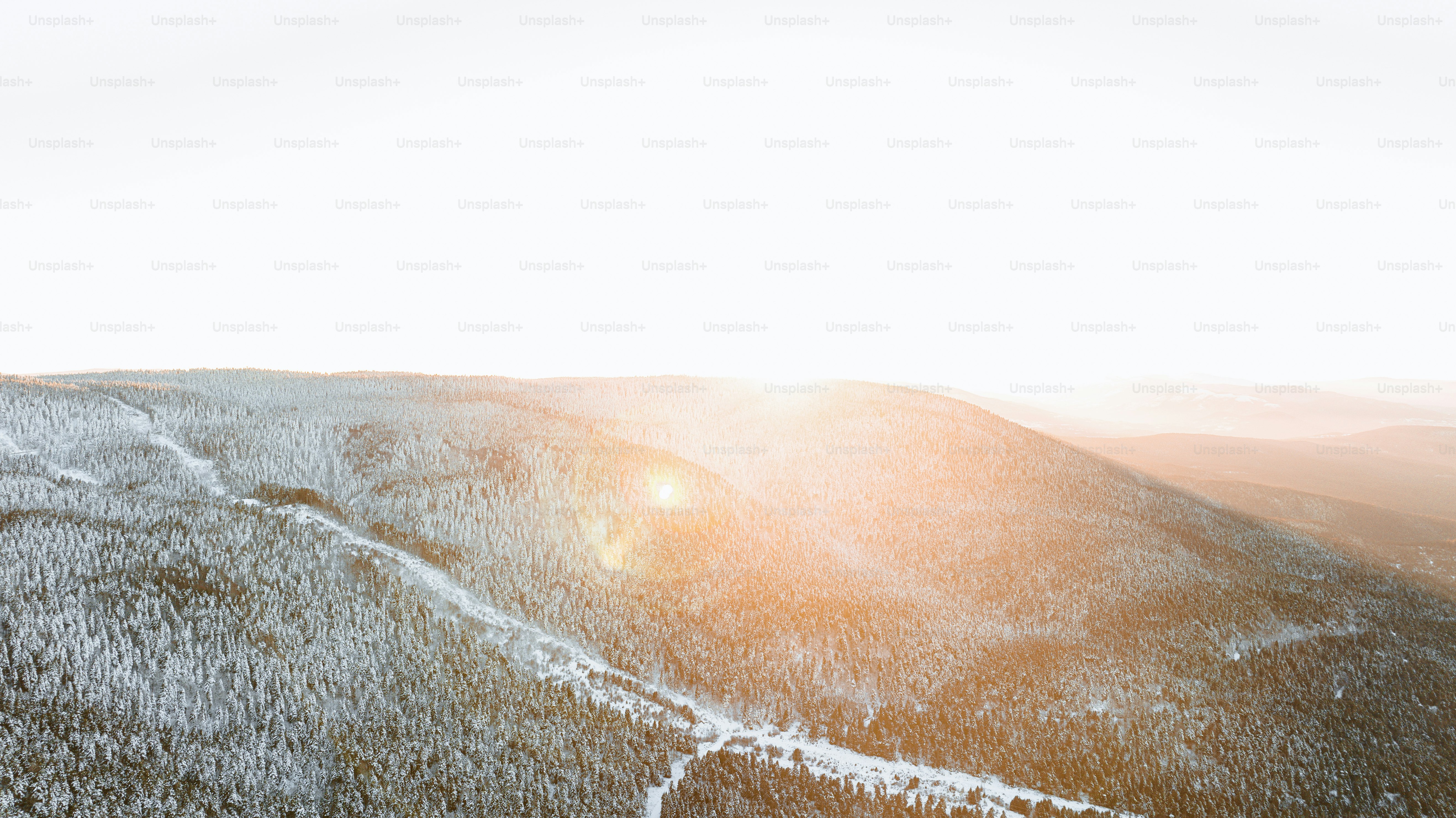 Die Sonne scheint hell auf einen verschneiten Berg