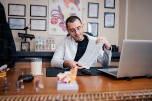 a man sitting at a desk reading a piece of paper