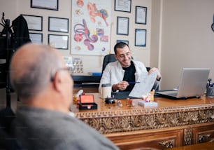 um homem sentado em uma mesa na frente de um computador portátil