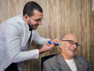 Ein Mann, der sich von einem Mann im Anzug die Zähne putzen lässt