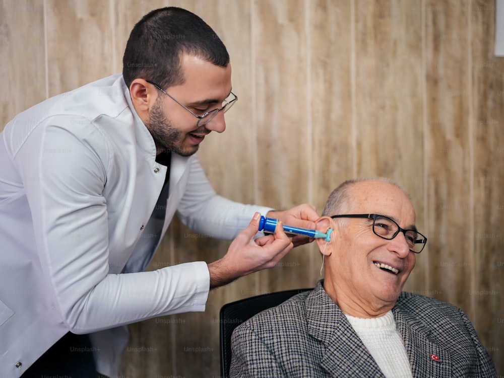 a man getting his teeth brushed by a man in a suit
