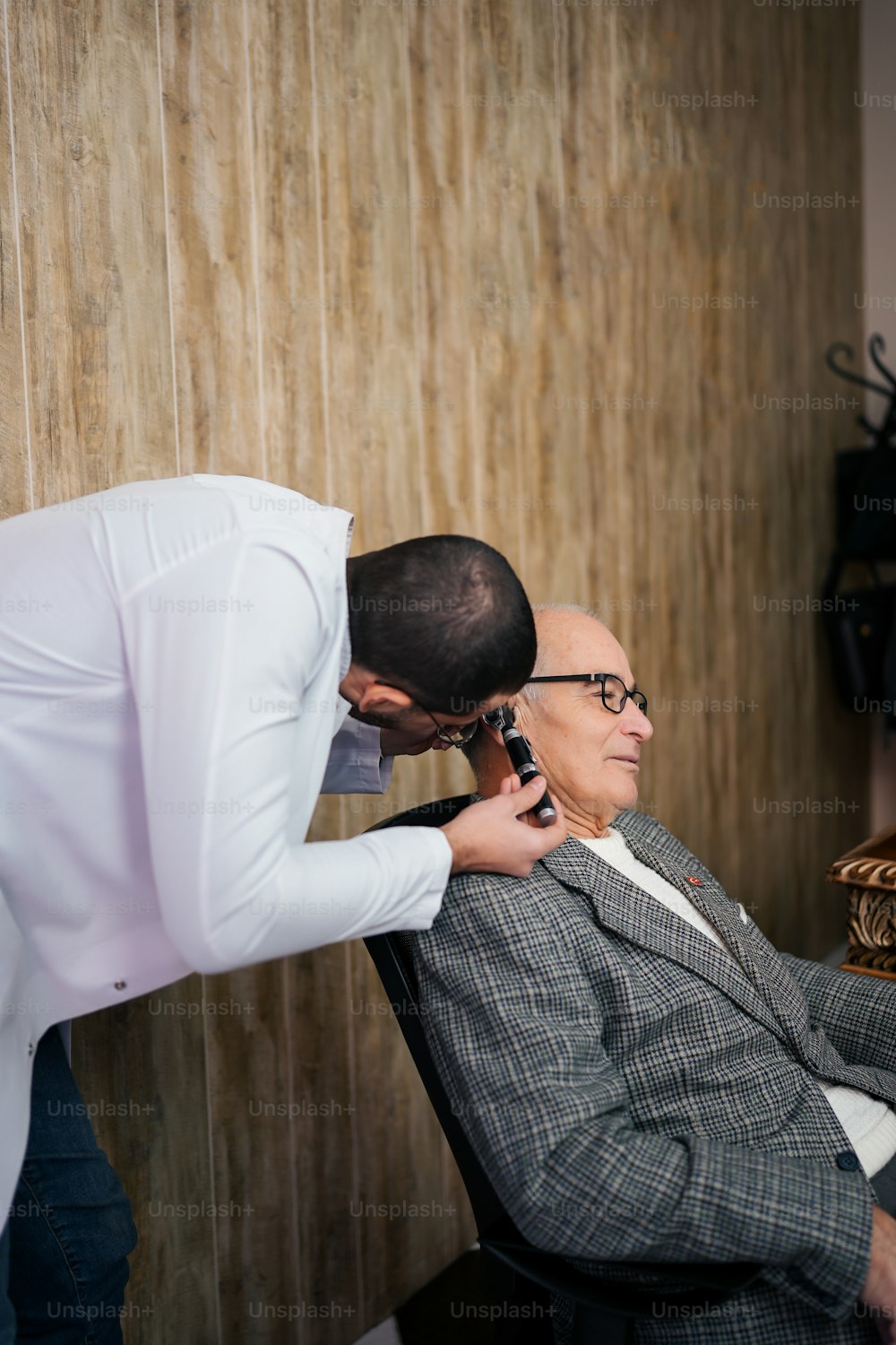 a man in a suit getting a haircut from a man in a chair