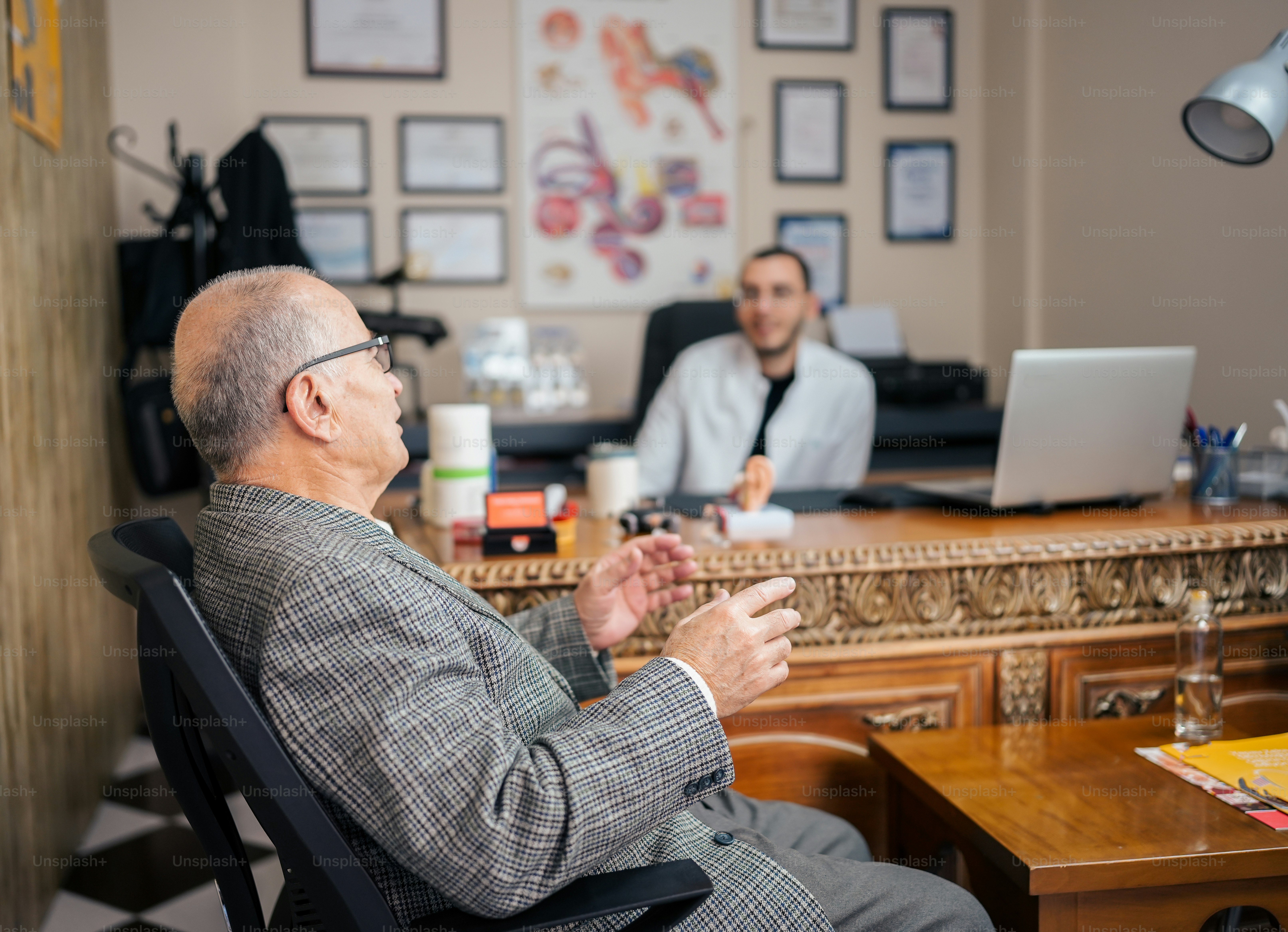 a man sitting at a desk in front of a laptop computer
