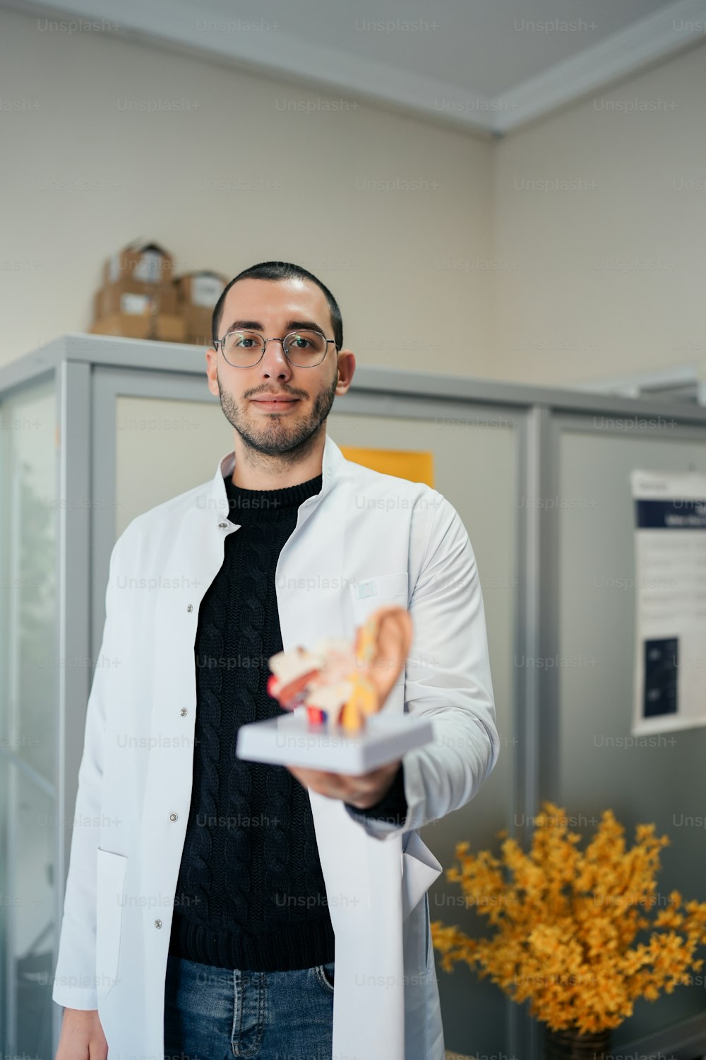 a man in a lab coat holding a piece of food
